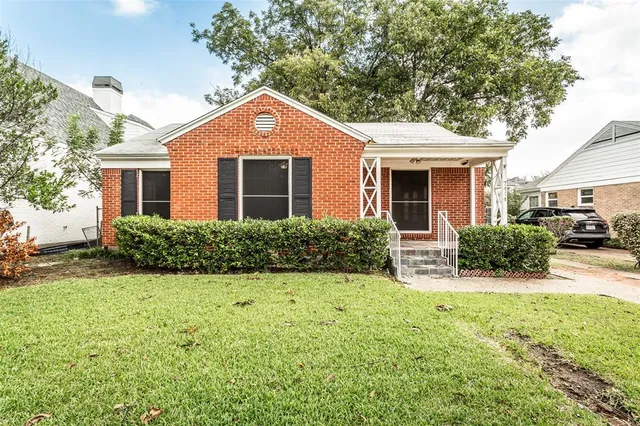 a front view of a house with yard and green space