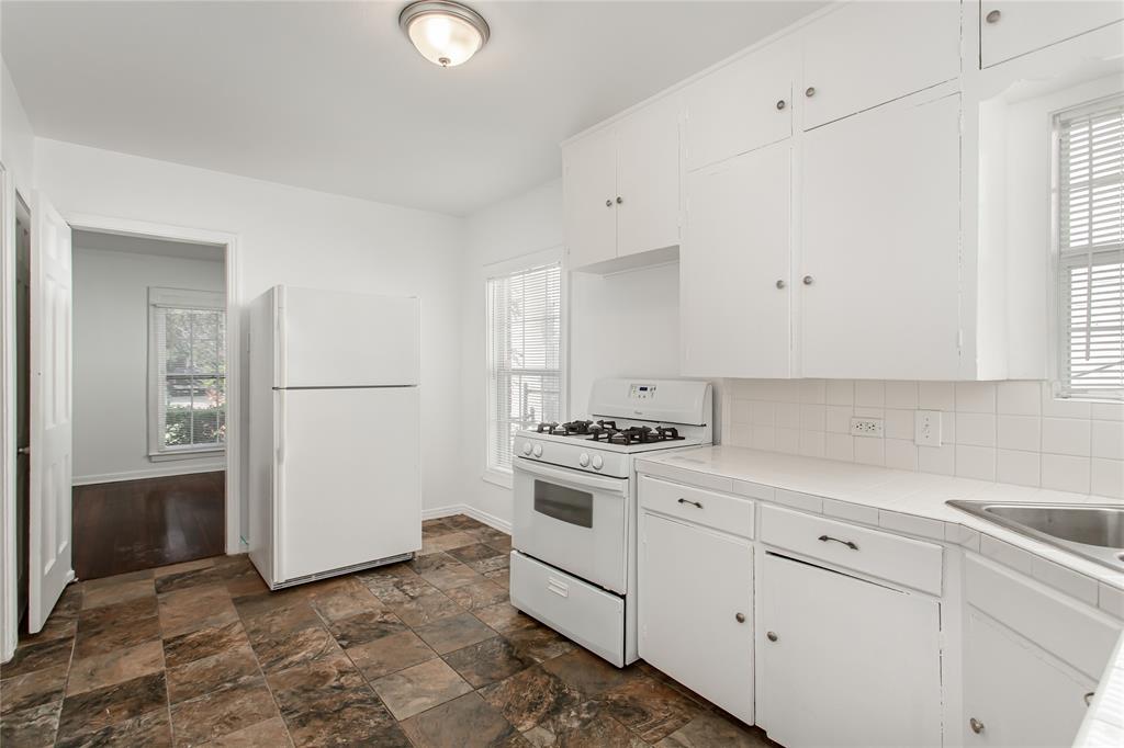 7414 Robin Road Dallas, TX 75209 - Photo 15 of 31 a kitchen with white cabinets and white appliances