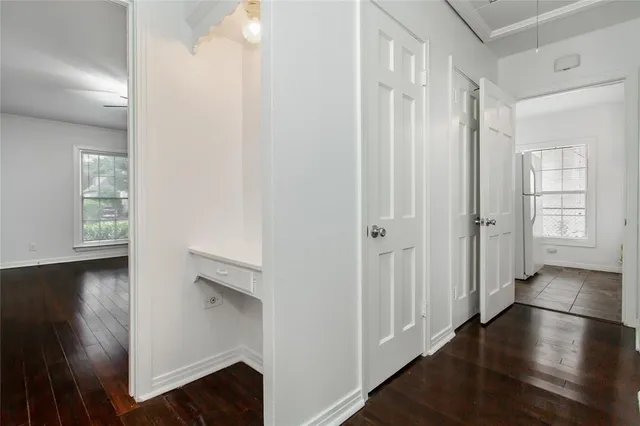 an empty room with chandelier fan and windows