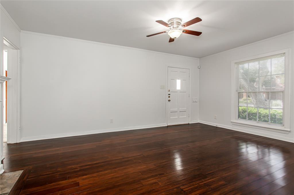7414 Robin Road Dallas, TX 75209 - Photo 8 of 31 an empty room with wooden floor and chandelier fan