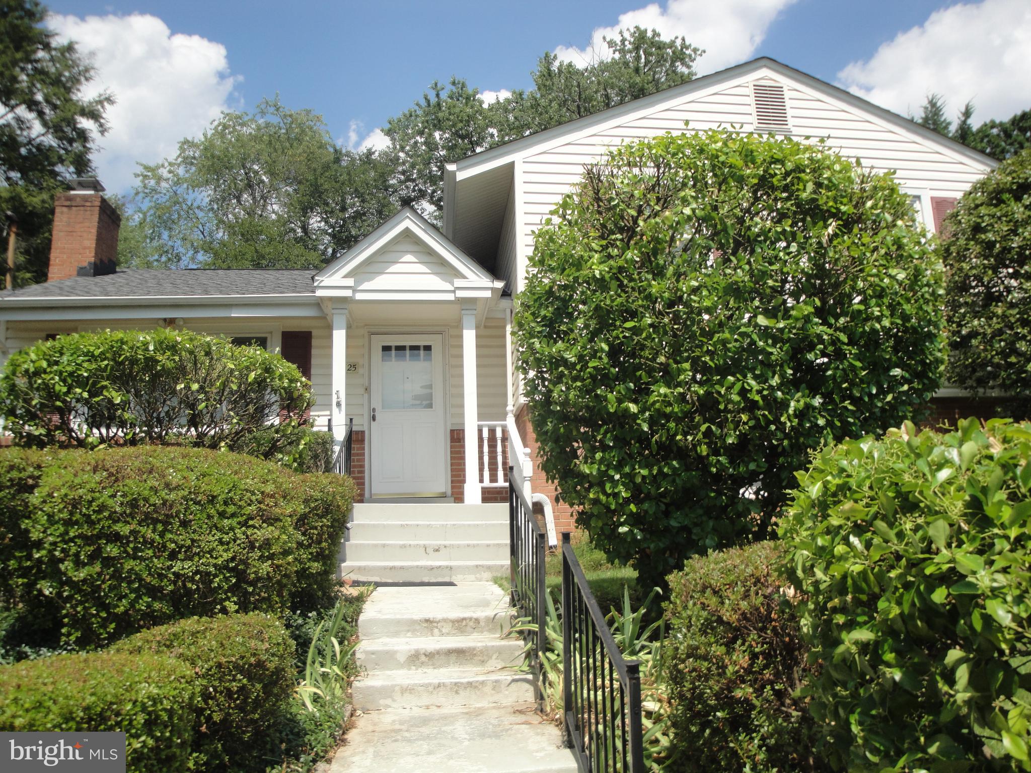 a front view of a house with a yard and fountain in middle