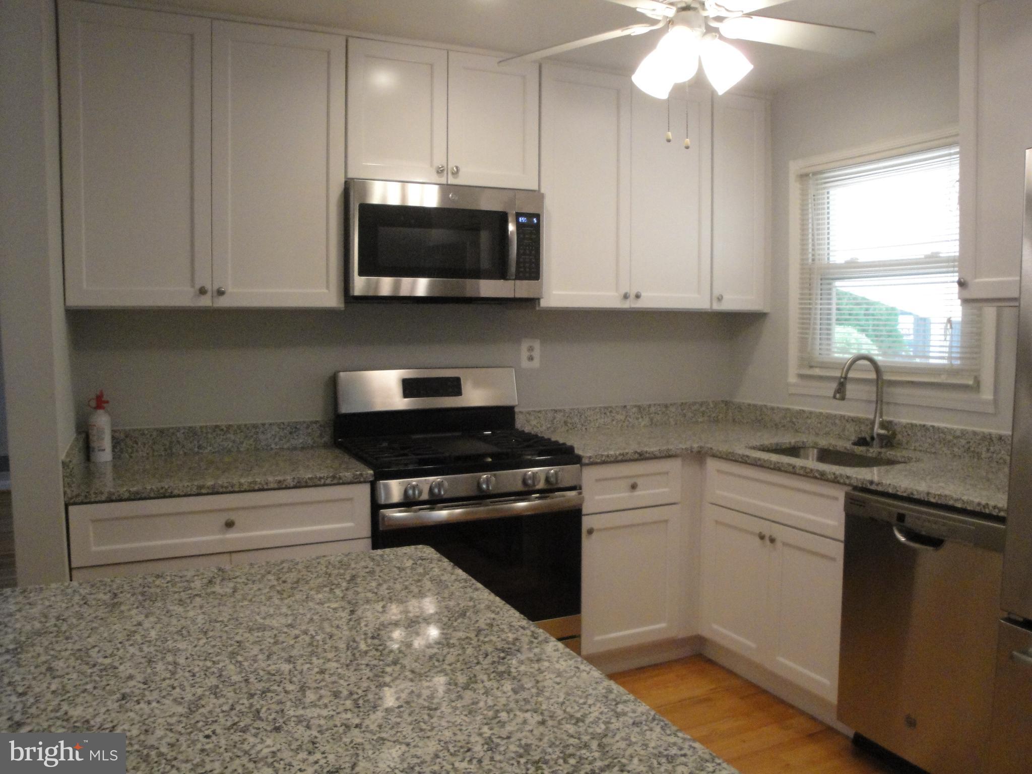 1825 Opalocka Drive McLean, VA 22101 - Photo 14 of 28 a kitchen with stainless steel appliances granite countertop a stove a sink and a microwave