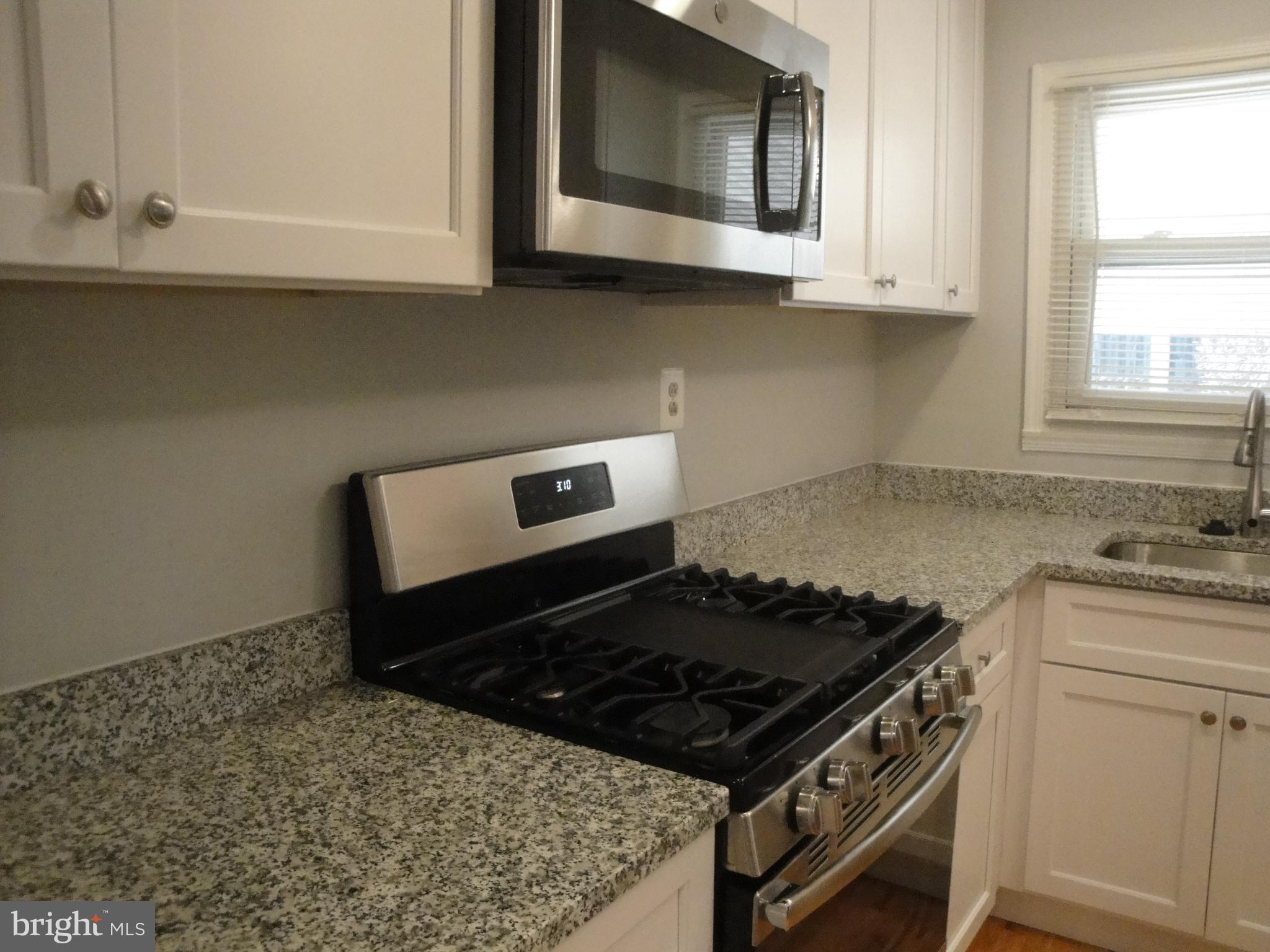 1825 Opalocka Drive McLean, VA 22101 - Photo 27 of 28 a kitchen with granite countertop a stove and a white cabinets