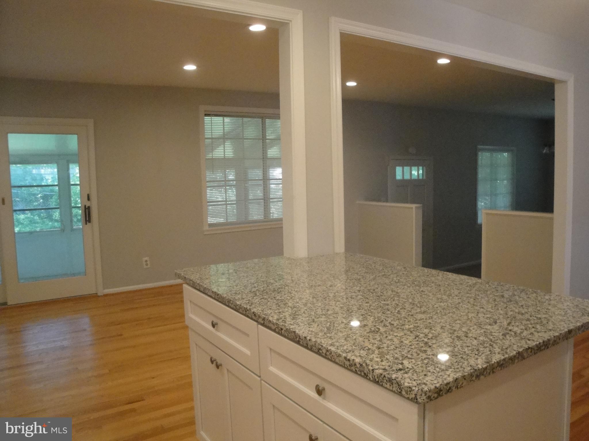 1825 Opalocka Drive McLean, VA 22101 - Photo 28 of 28 a kitchen with kitchen island a sink granite counter tops and a wooden floor