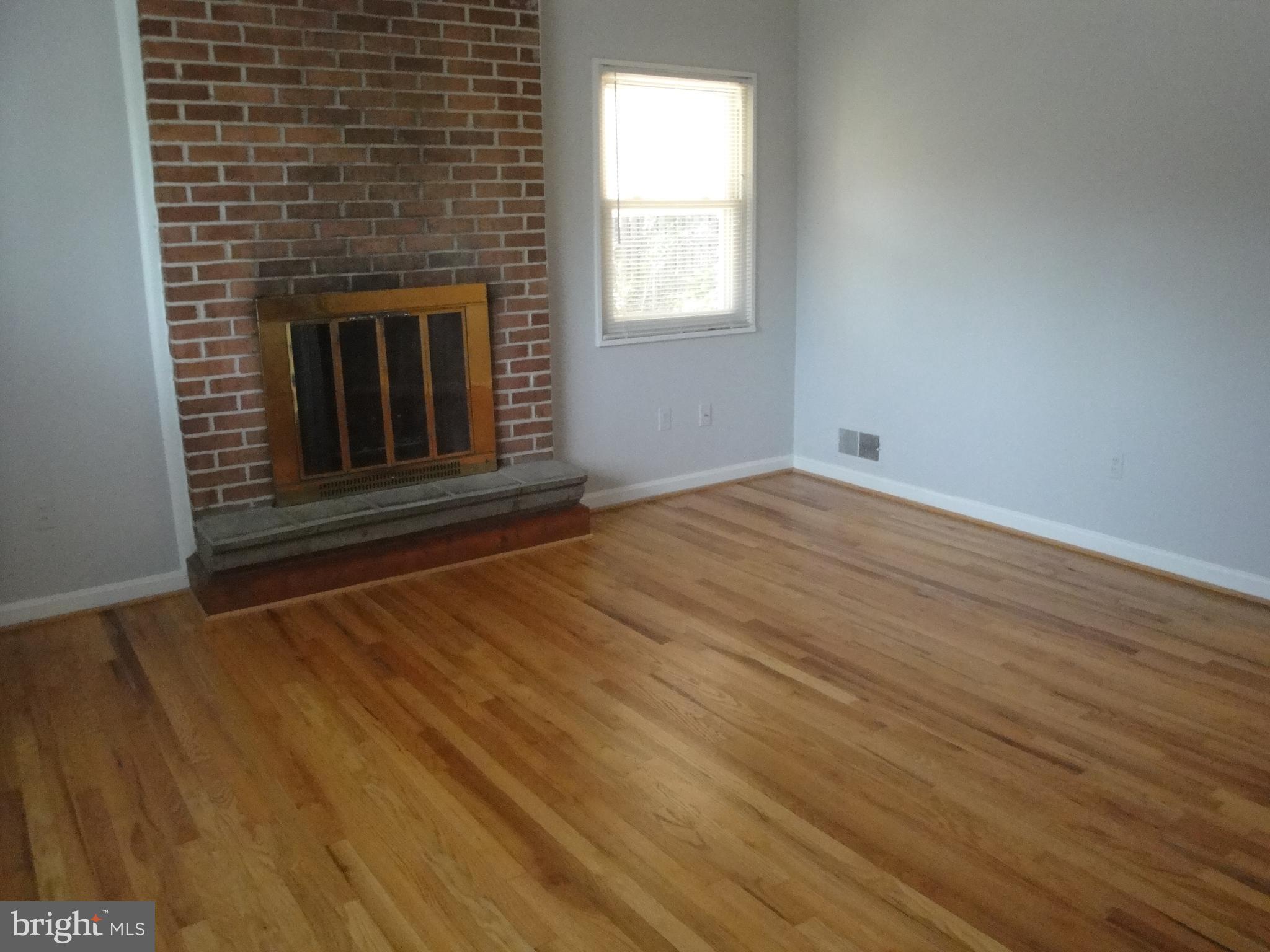 1825 Opalocka Drive McLean, VA 22101 - Photo 8 of 28 an empty room with wooden floor fireplace and windows