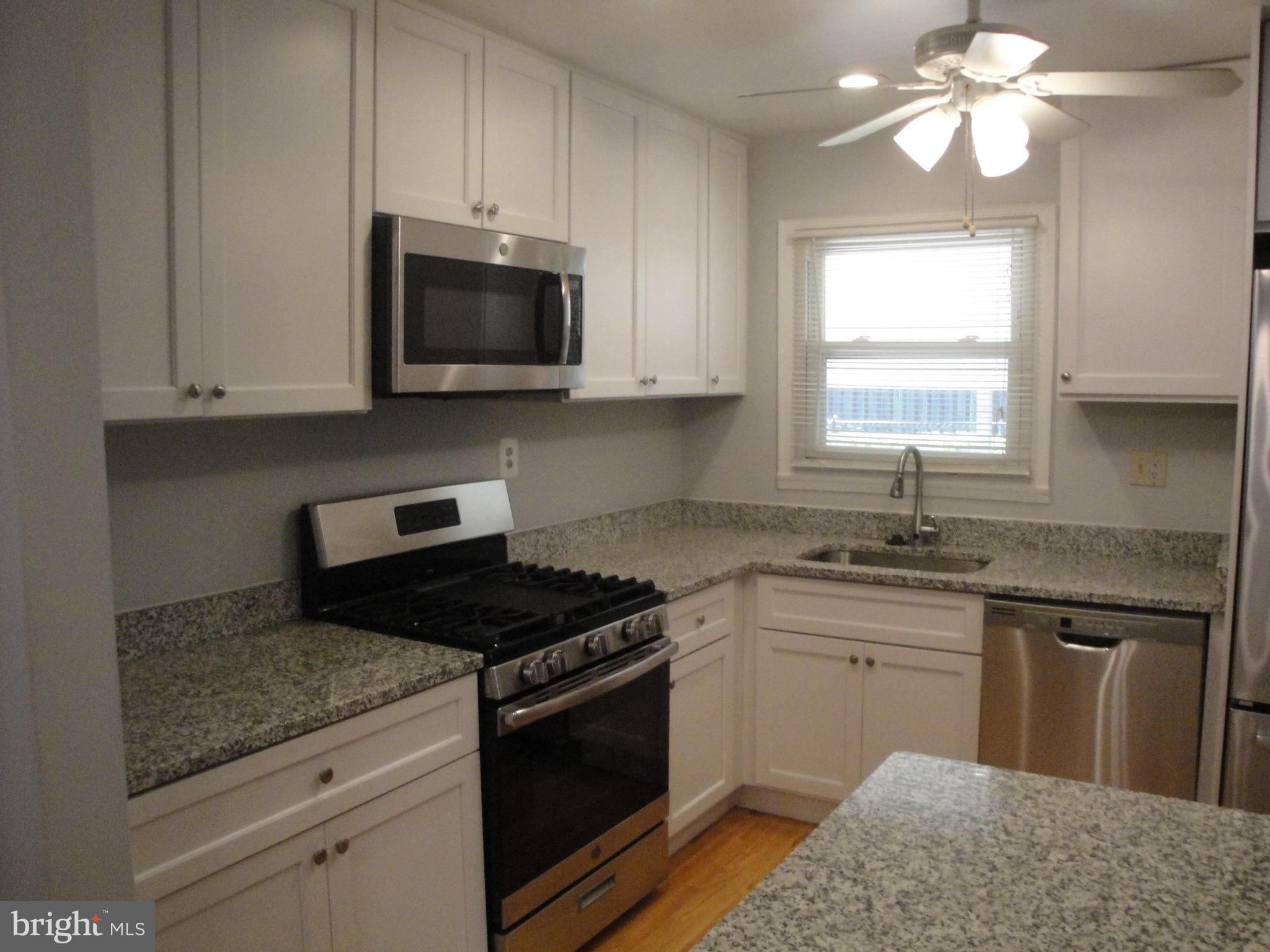1825 Opalocka Drive McLean, VA 22101 - Photo 10 of 28 a kitchen with granite countertop a sink cabinets and stainless steel appliances