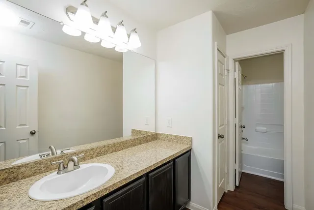 a bathroom with a granite countertop sink and a mirror