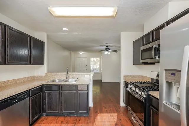 a kitchen with stainless steel appliances sink stove microwave and cabinets