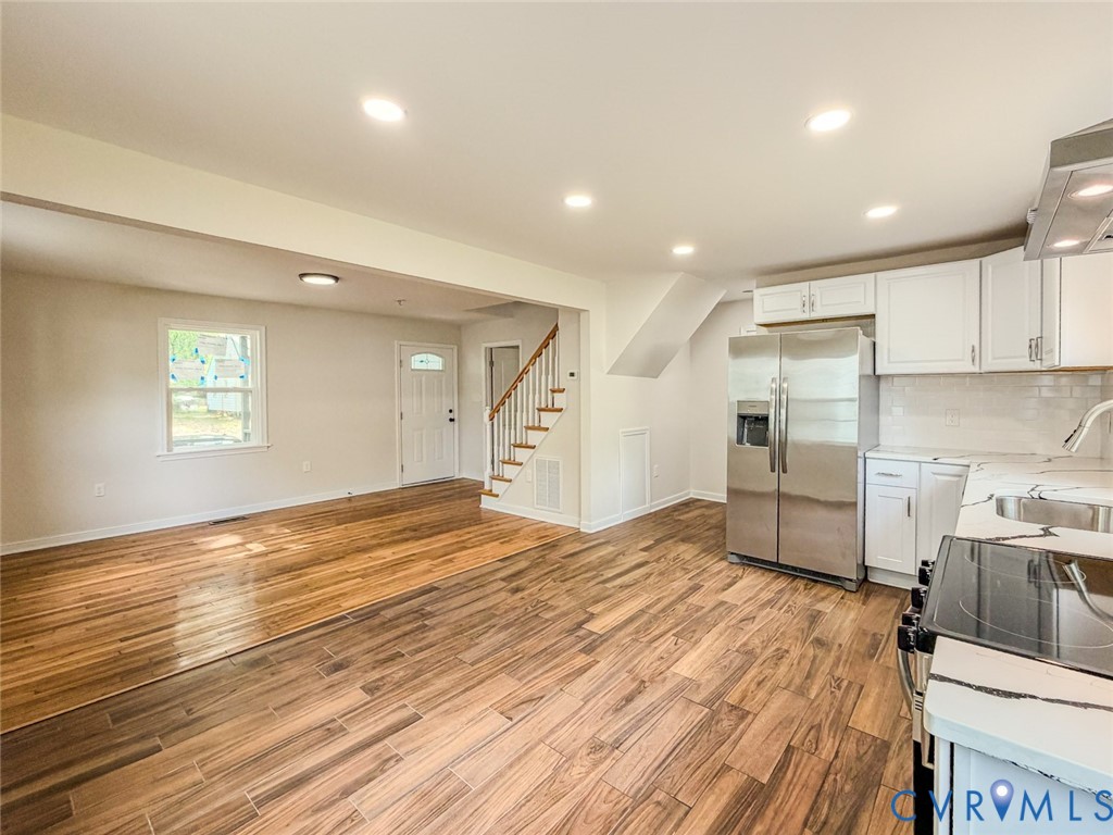 3409 Meadowbridge Road Richmond, VA 23222 - Photo 4 of 32 a large kitchen with kitchen island a stove a sink dishwasher and a refrigerator with wooden floor