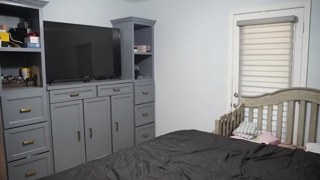 a work room with furniture a flat screen tv and a window