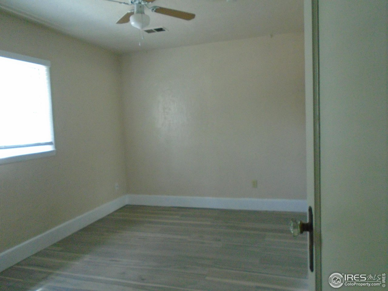 116 Walnut Street Windsor, CO 80550 - Photo 6 of 13 an empty room with a window and a fan