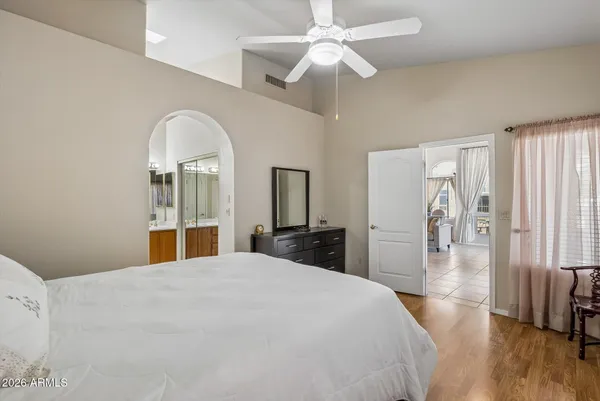a bedroom with a large bed and a chandelier