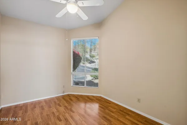 an empty room with windows and ceiling fan