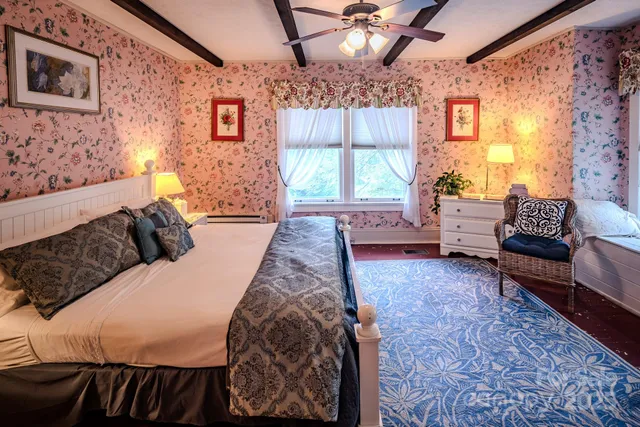 a spacious bedroom with a bed and a chandelier