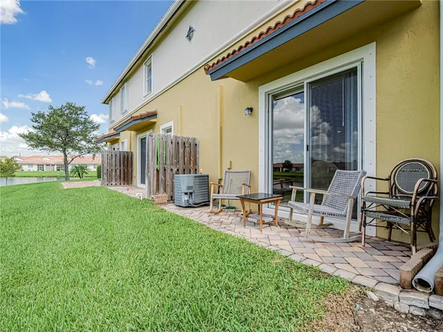 a view of house with backyard and outdoor seating