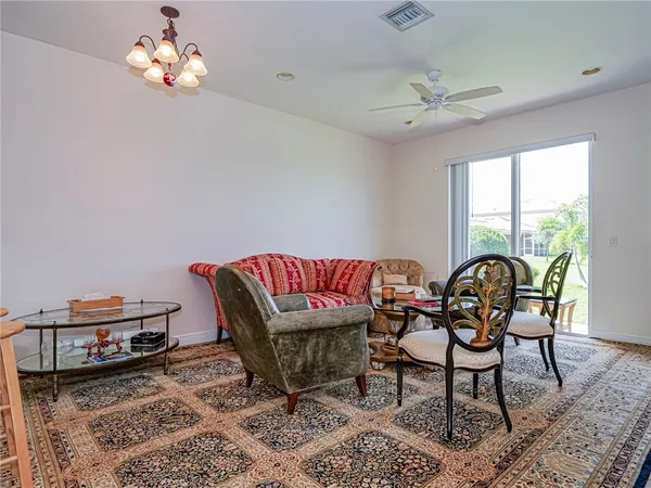 a living room with furniture kitchen view and a chandelier