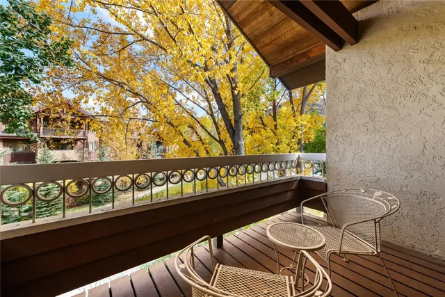 a two chairs sitting in a balcony with wooden fence