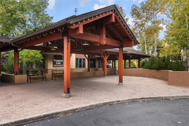 a patio with a table and chairs and potted plants
