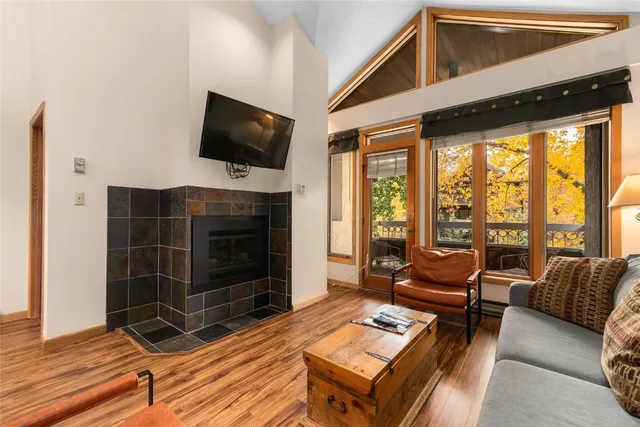 a living room with furniture a flat screen tv and a floor to ceiling window