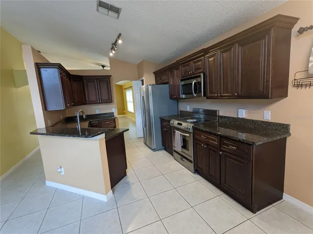a kitchen with stainless steel appliances granite countertop a stove a microwave and a refrigerator