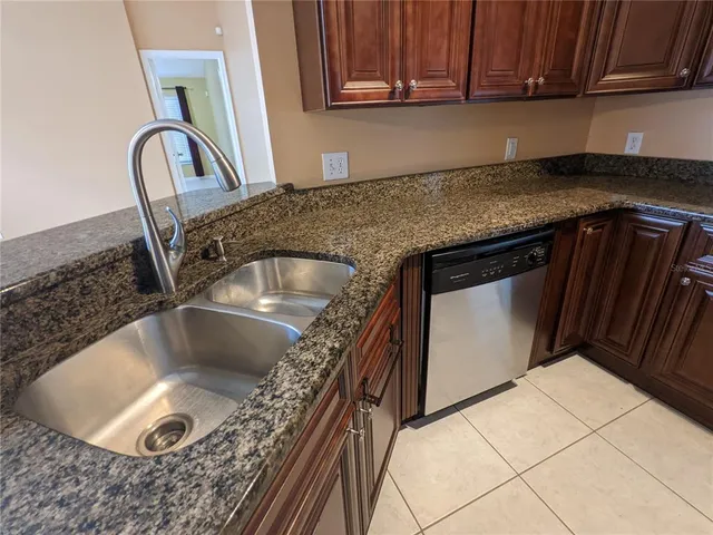 a kitchen with granite countertop a sink and a stove