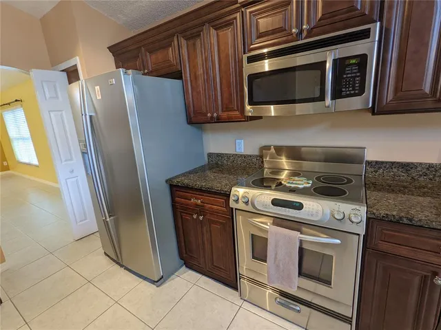 a kitchen with stainless steel appliances wooden cabinets and a stove top oven