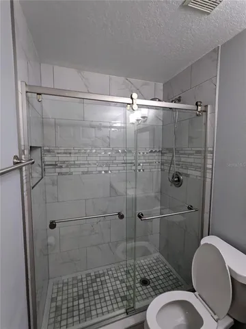 a bathroom with a shower a toilet and sink