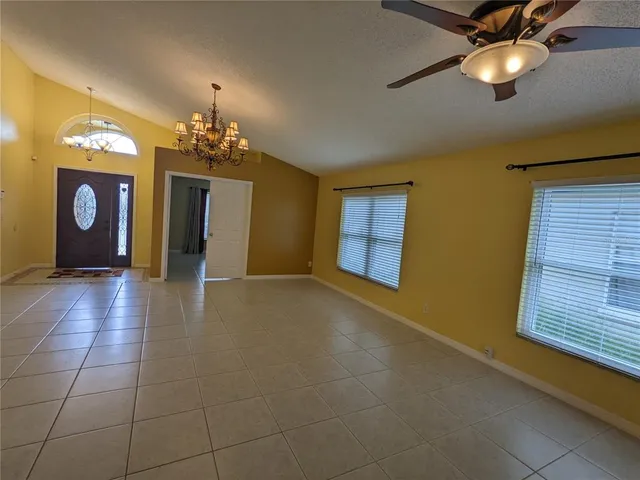 a view of a livingroom with a chandelier fan and a kitchen