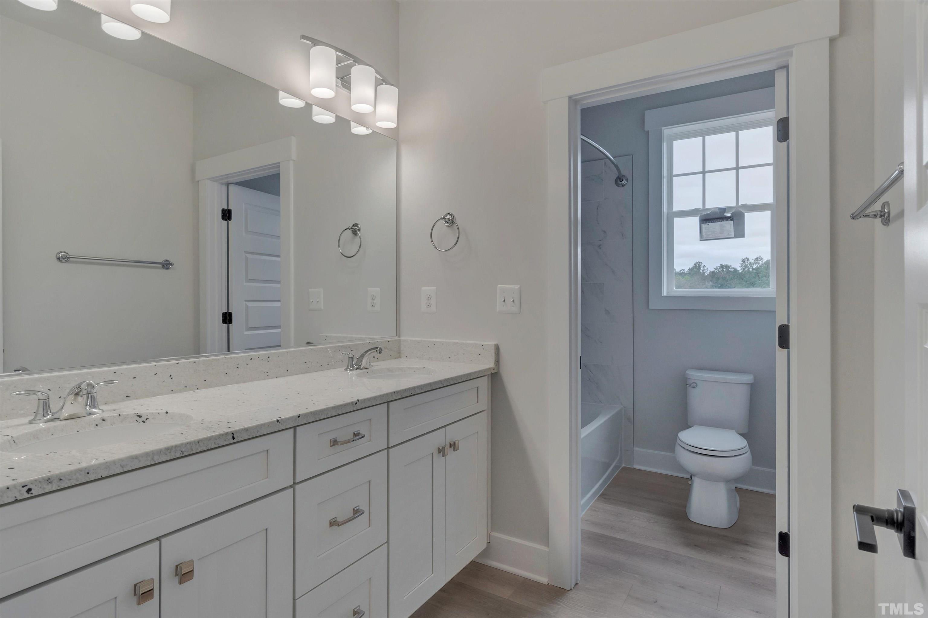 188 Dunloe Loop Raleigh, NC 27603 - Photo 13 of 13 a bathroom with a granite countertop sink a toilet and a mirror