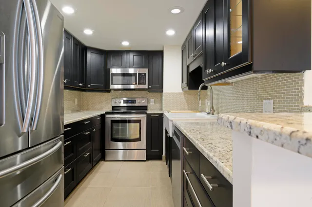 a kitchen with stainless steel appliances granite countertop a sink stove and refrigerator