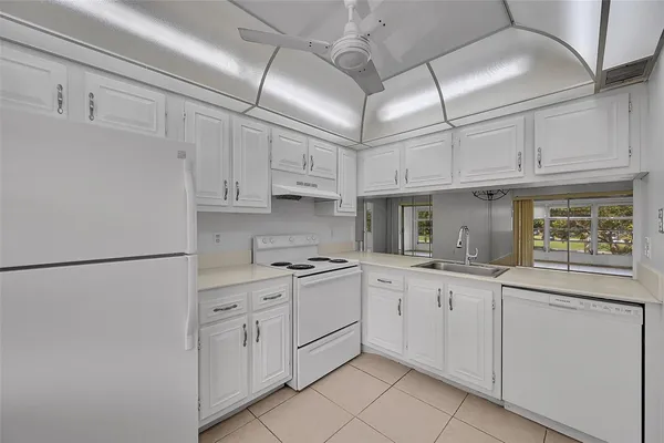 a kitchen with cabinets appliances a sink and a window