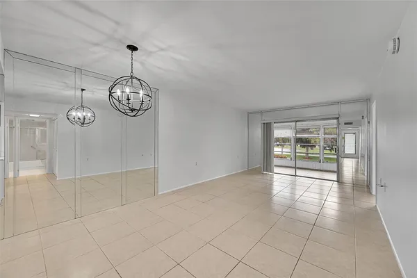 an empty room with windows and chandelier