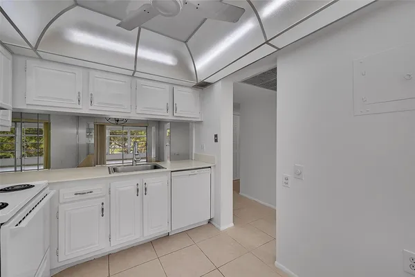 a kitchen with white cabinets and sink
