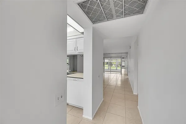 a hallway with white cabinets and wooden floor