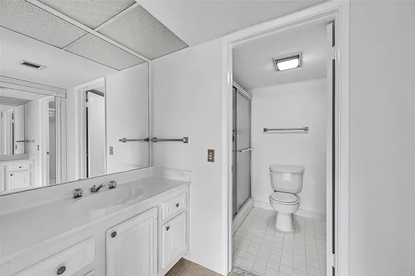 a bathroom with a granite countertop sink a toilet and a shower