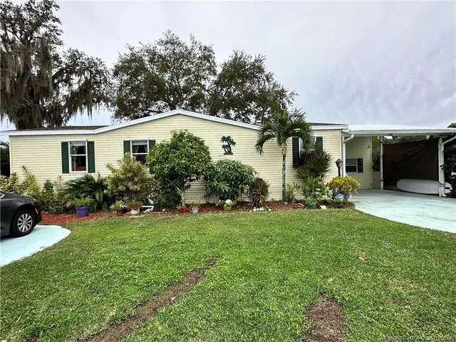 a kitchen with stainless steel appliances granite countertop a refrigerator a stove a sink dishwasher and wooden cabinets with wooden floor