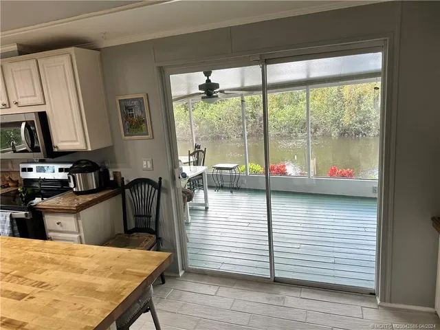 a view of a dining room with furniture a chandelier and wooden floor