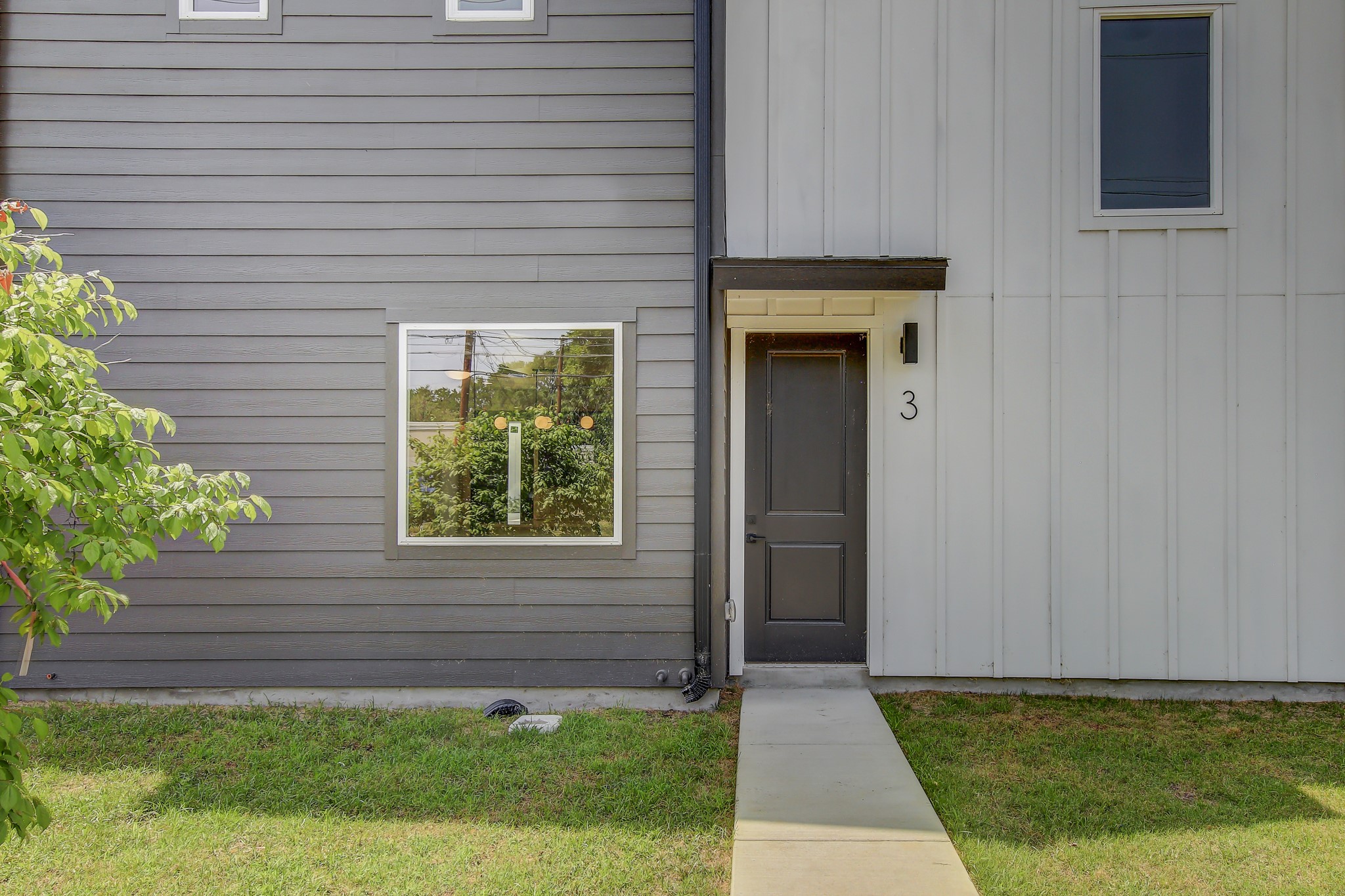4127 East 12th Street, Unit 3 Austin, TX 78721 - Photo 28 of 29 Entrance to property featuring a lawn and board and batten siding