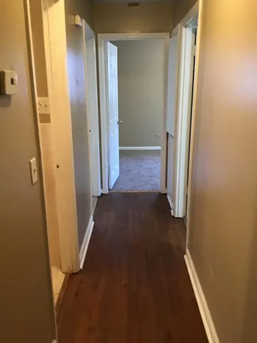 view of a hallway with wooden floor and closet area