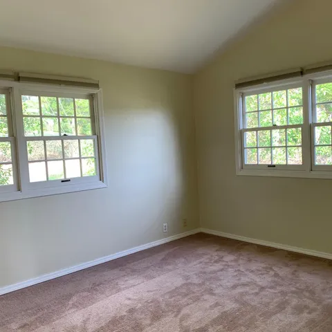 an empty room with windows and closet
