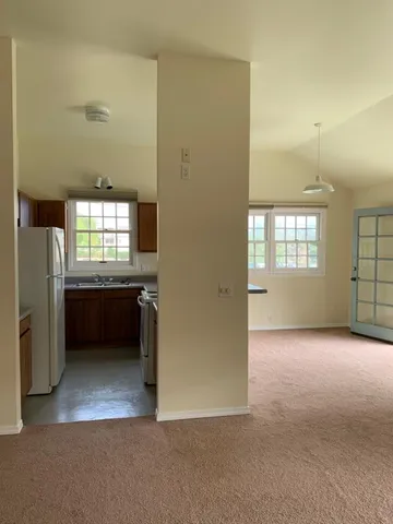 an empty room with a kitchen and window