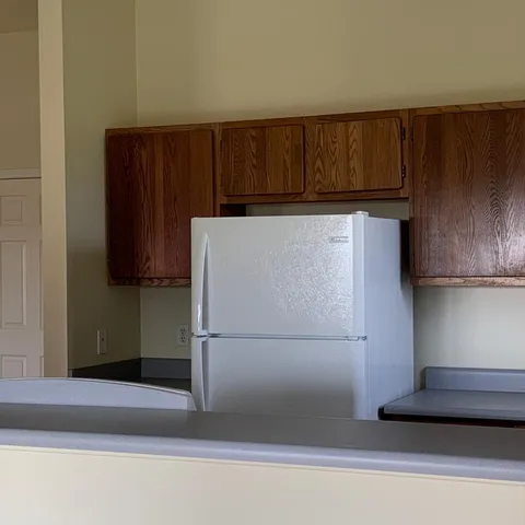 a view of a refrigerator in kitchen and wooden floor