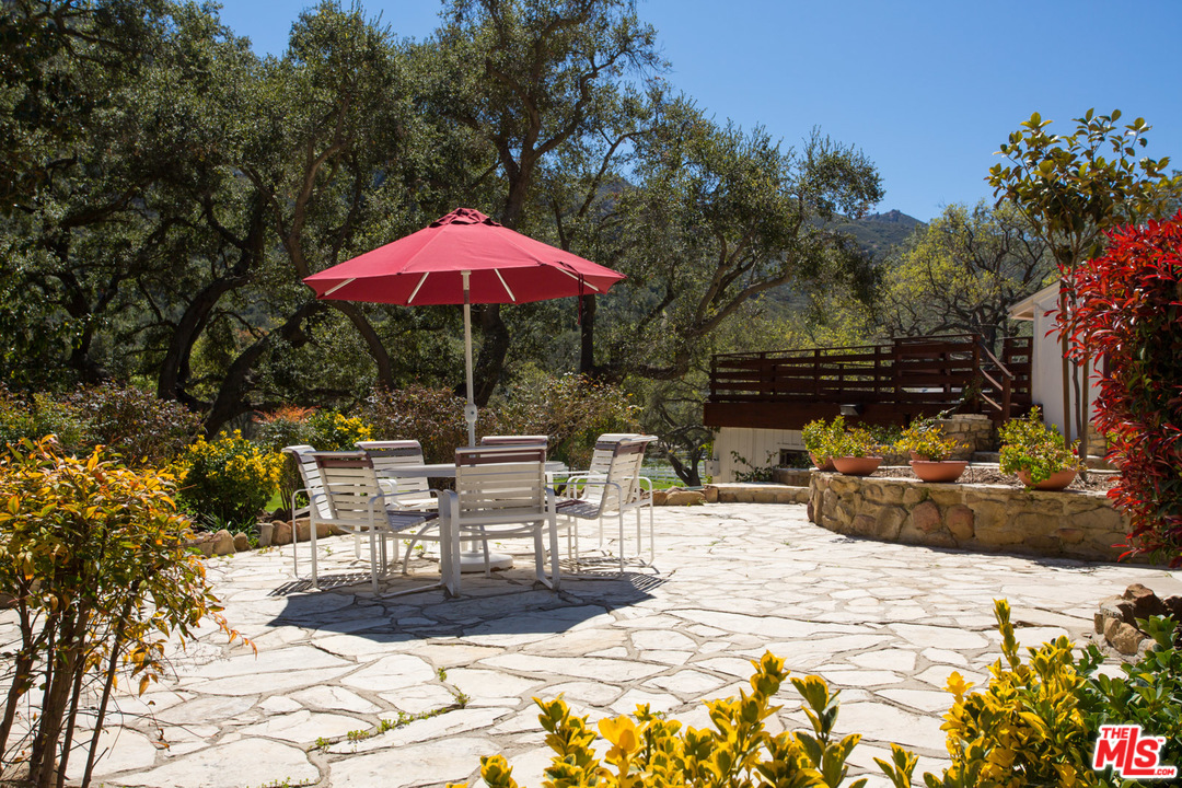 1753 Hidden Valley Road Thousand Oaks, CA 91361 - Photo 18 of 43 a view of a patio with a table and chairs under an umbrella