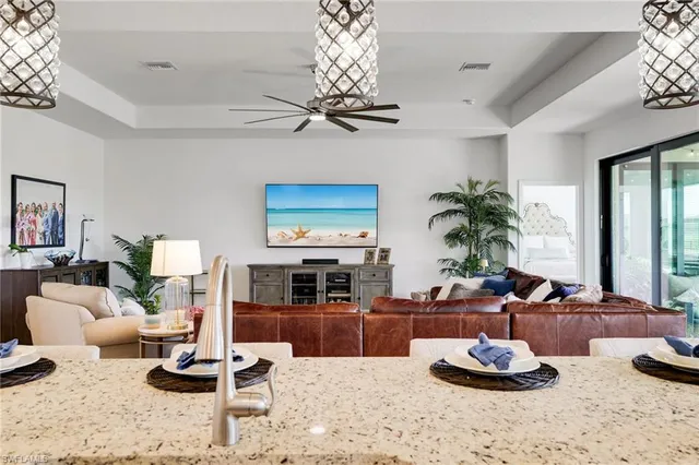 a living room with furniture a chandelier and a large window