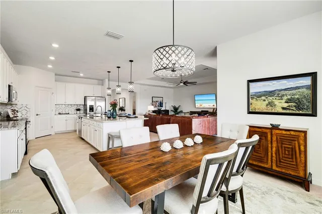 a dining room with wooden floor a chandelier a wooden table and chairs