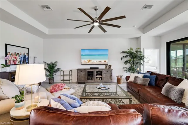 a living room with furniture ceiling fan and a large window