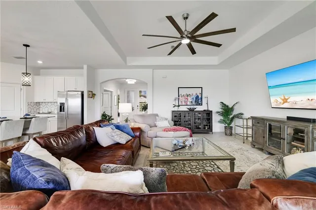 a living room with furniture kitchen view and a wooden floor