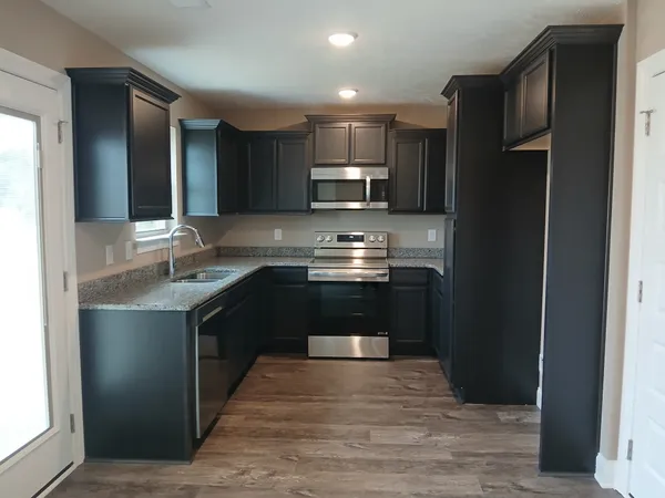 a kitchen with stainless steel appliances granite countertop a refrigerator stove and sink