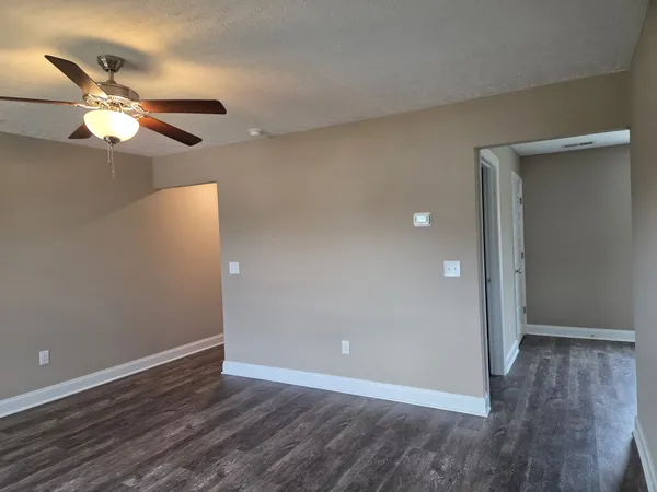an empty room with a window and a ceiling fan