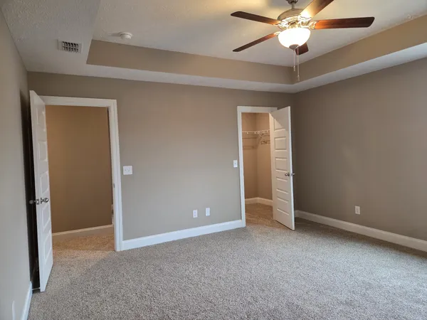 an empty room with a window and a fan